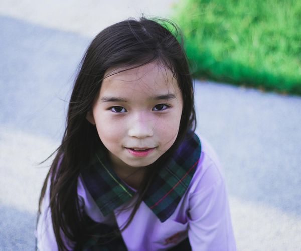 Person smiling and stretching outdoors, looking peaceful and happy.